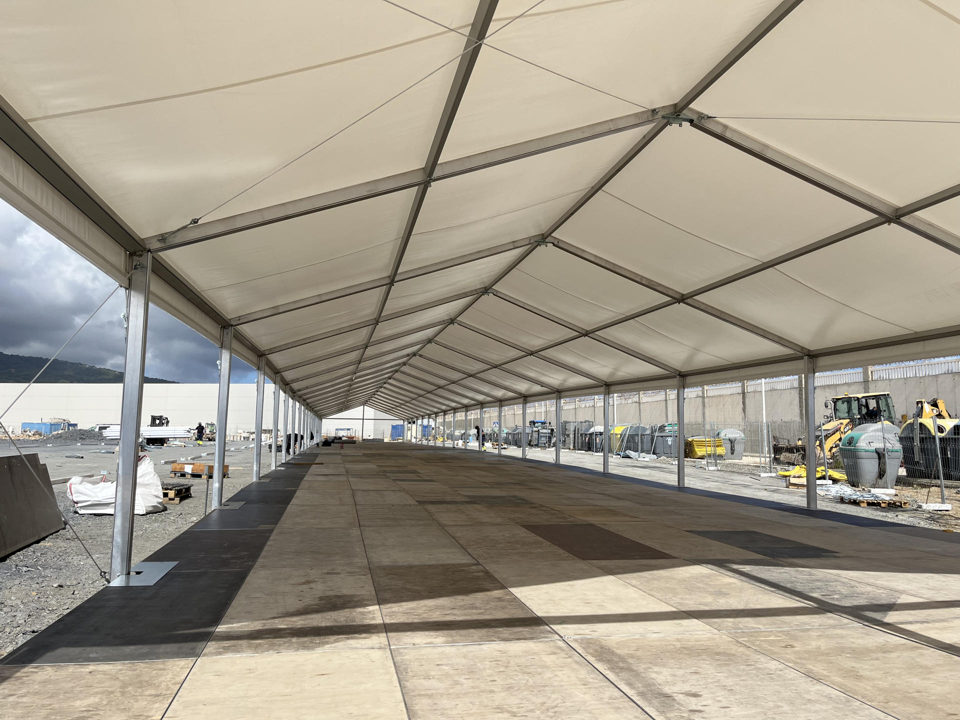 CEUTA (ESPAÑA), 11/09/2026.- Operarios preparan una carpa de grandes dimensiones en muelle Poniente del puerto de Ceuta que tendrá una capacidad para alojar a mil migrantes. EFE/ Reduan