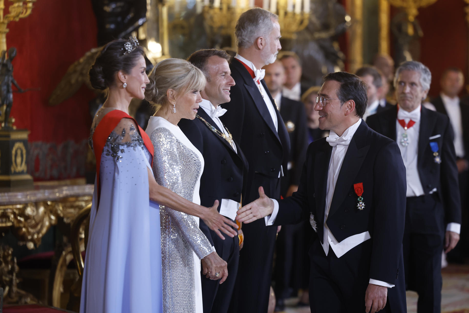 MADRID, 29/09/2026.- Los reyes de España, Felipe VI y Letizia (i), y el presidente de la República de Francia, Emmanuel Macron (3-i), y la primera dama Brigitte Macron (2-i) saludan al ministro de Asuntos Exteriores español, José Manuel Albares (d), a su llegada a la cena de gala que se celebra este martes en el Palacio Real, en Madrid. EFE/Daniel González