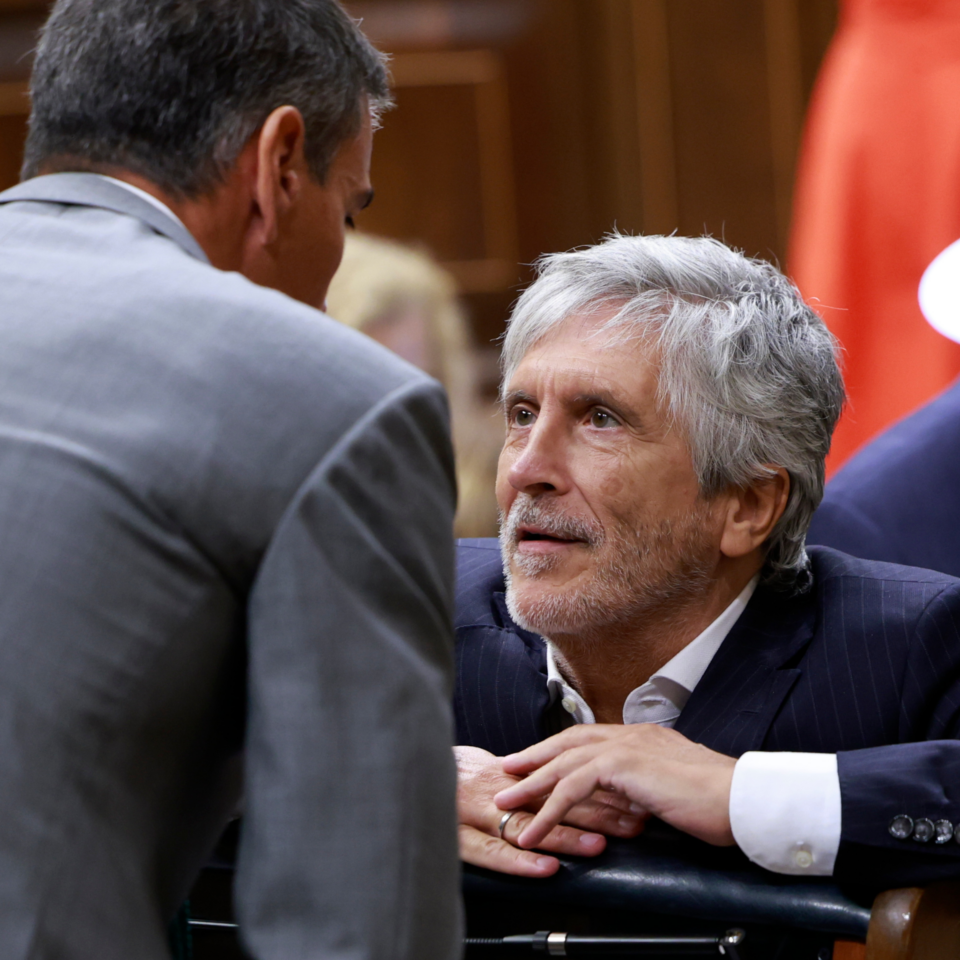 Fernando Grande-Marlaska (d), conversa con el presidente del Gobierno, Pedro Sánchez, en el Congreso de los Diputados, este jueves.