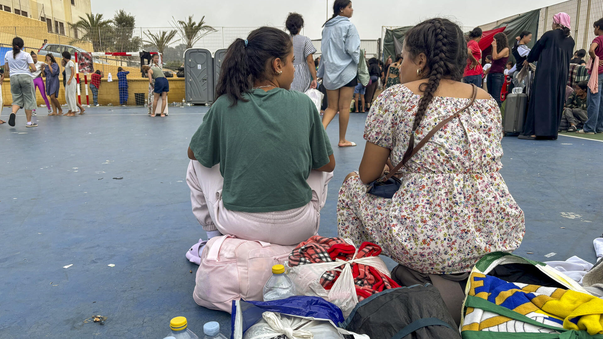 CEUTA, 04/09/2026.-Nour y su hermana, que cruzaron juntas a Ceuta el pasado 31 de julio. Ahora están en el campanento improvisado por los vecinos en el barrio de El Príncipe, en Ceuta. Cada mañana, Nour repite una rutina que se ha convertido en su particular condena: recoge meticulosamente sus pertenencias, ordena la poca ropa de la que dispone y cierra su maleta. Lleva exactamente doce días haciéndolo. Doce jornadas consecutivas escuchando la misma promesa por parte de los coordinadores y voluntarios del recinto: "Hoy sí, hoy os trasladan al centro". Pero cae la noche, las maletas vuelven a abrirse sobre el suelo y la espera se reinicia.Nour es una joven de 17 años de Tetuán que cruzó a nado a Ceuta el pasado 31 de julio junto a su hermana de 16 años y su hermano de 15.-EFE/ Laura Rincón