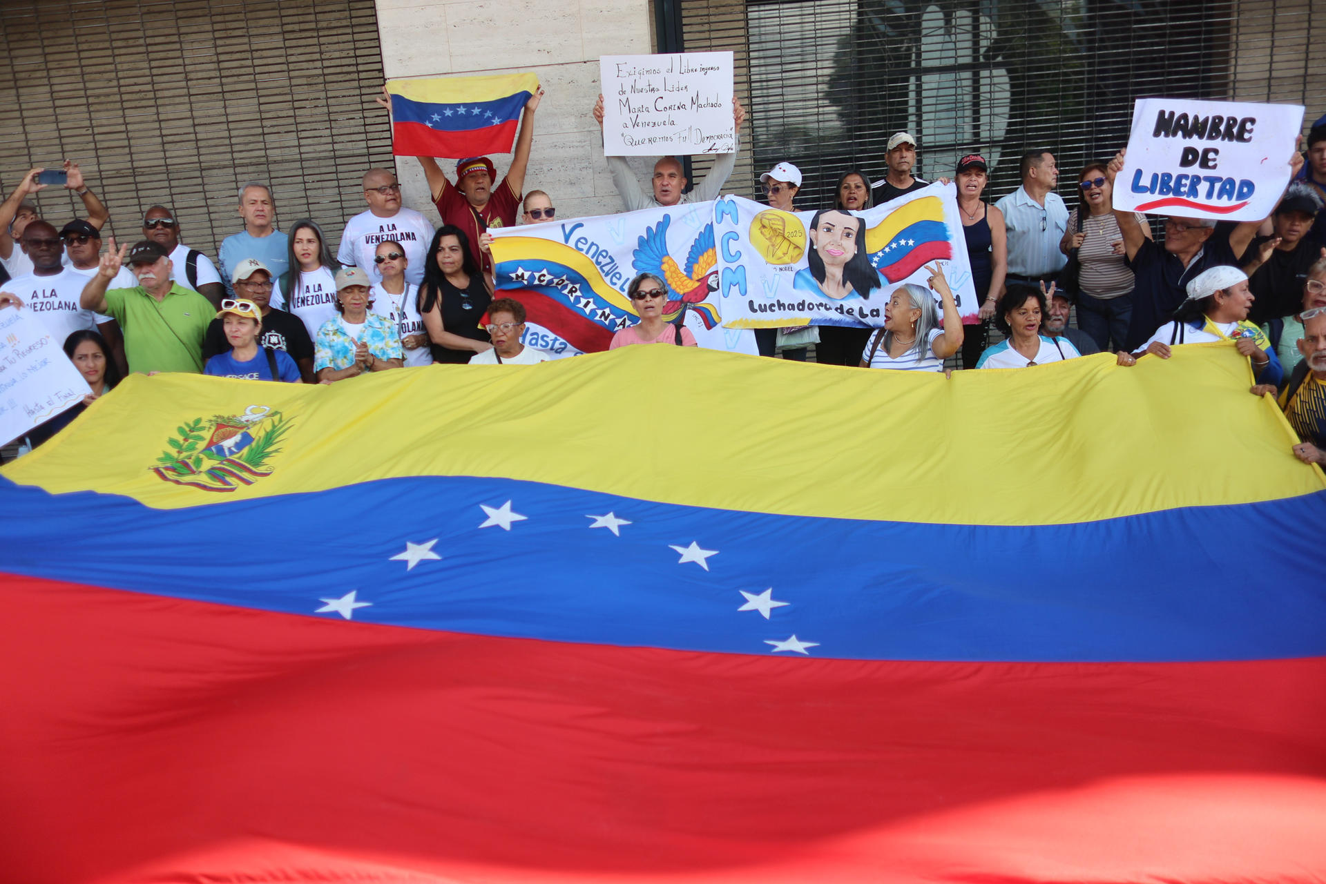 FOTODELDÍA - AME147. CARACAS (VENEZUELA), 24/09/2026.- Personas sostienen una bandera durante una manifestación para exigir el regreso de la líder de la oposición y premio nobel de la paz María Corina Machado a Venezuela, este jueves en Caracas (Venezuela). EFE/Miguel Gutiérrez