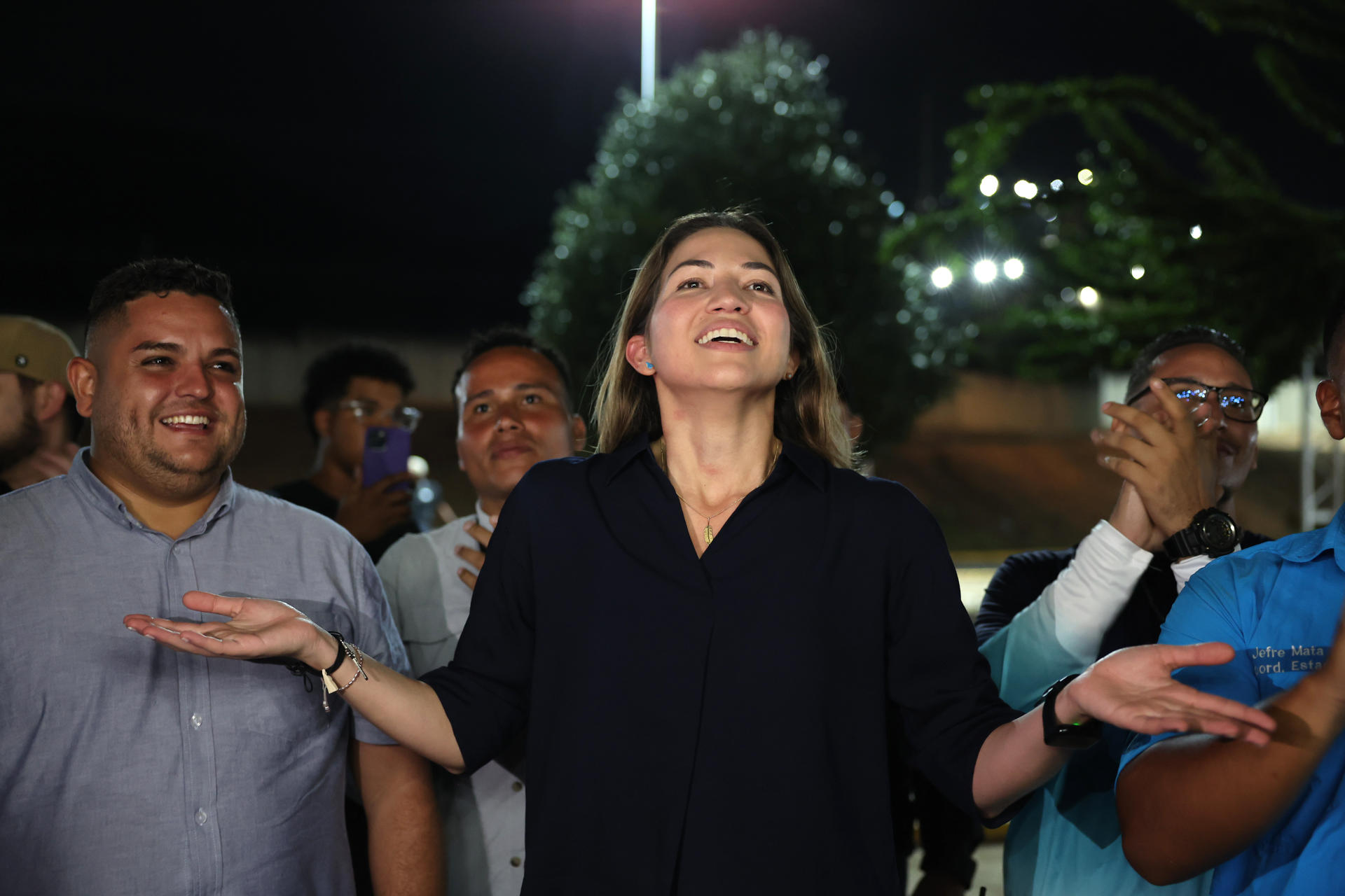 AME1070. MAIQUETÍA (VENEZUELA), 27/09/2026.- La opositora venezolana Claudia Macero (c), jefa de prensa de la líder María Corina Machado, reacciona a simpatizantes de la regional Vente Vargas del partido político Vente Venezuela a su regresó al país este domingo, de donde salió en el primer semestre de 2025 tras permanecer asilada junto a otros cinco compañeros en la residencia de la Embajada de Argentina en Caracas por acusaciones de supuesta conspiración y traición a la patria. EFE/ Miguel Gutiérrez