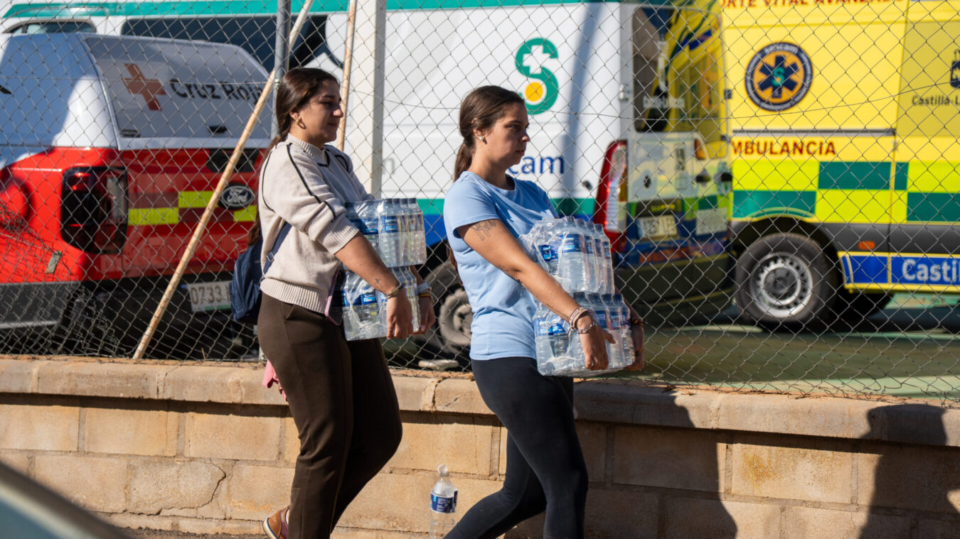 Varias mujeres cargan botellas de agua en las inmediaciones del accidente.