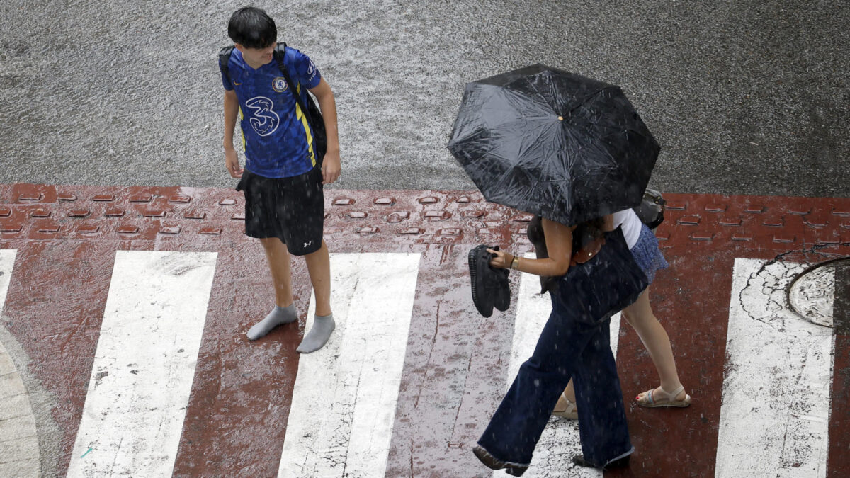 GRAFCAT6618. BARCELONA, 02/10/2026.- Varias personas en una calle del centro de Barcelona bajo la tormenta que ha caído este viernes cuando el presidente de la Generalitat, Salvador Illa, ha pedido "prudencia" a los ciudadanos ante el temporal de fuertes lluvias que afecta a Cataluña. EFE/Alberto Estévez