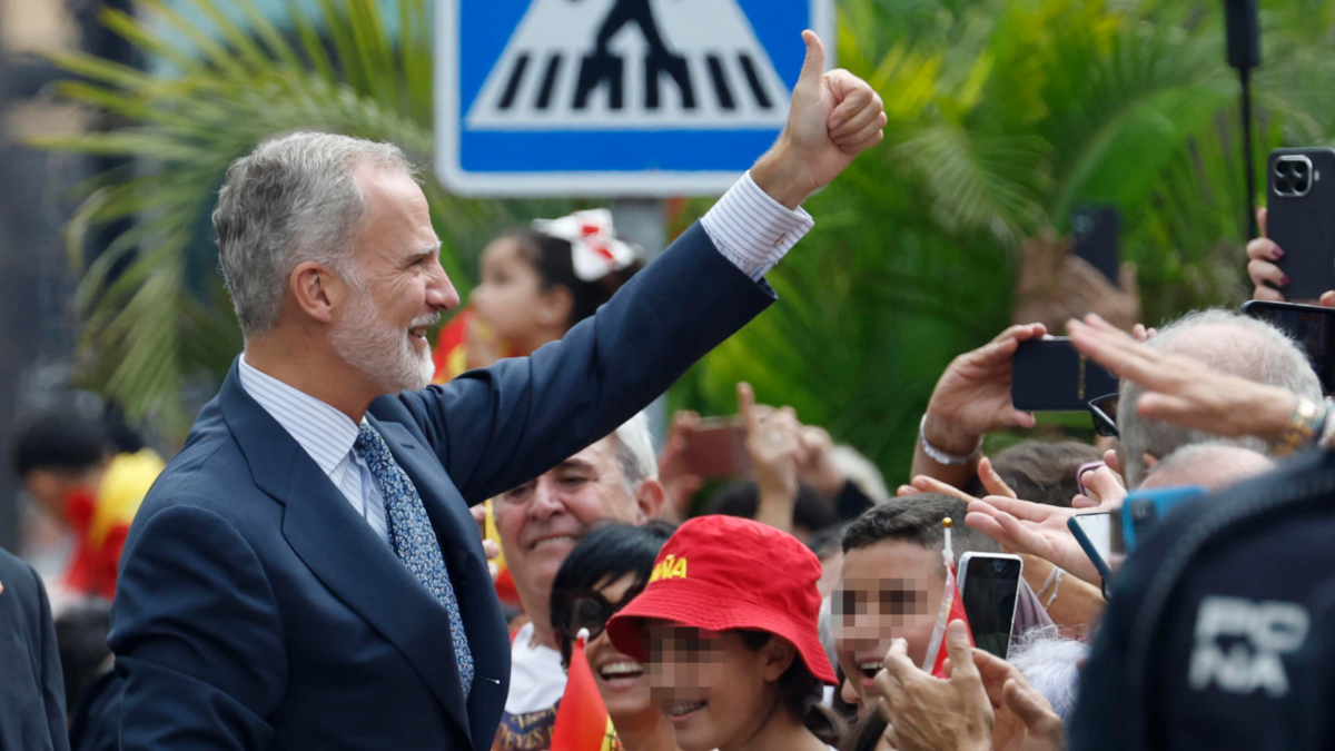 El rey Felipe VI saluda a la multitud que espera su llegada ante el Ayuntamiento.