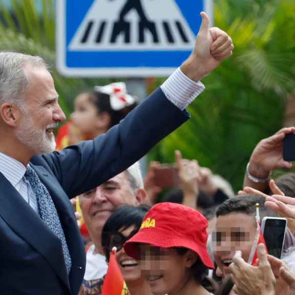 El rey Felipe VI saluda a la multitud que espera su llegada ante el Ayuntamiento.