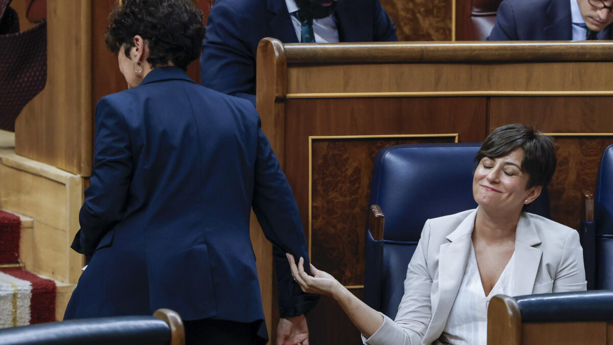 MADRID, 02/10/2026.- La portavoz del PNV, Maribel Vaquero (i, de espaldas), saluda a la titular de Vivienda, Isabel Rodríguez (d), durante el pleno en el que se debate y vota los decretos de vivienda del Gobierno celebrado este viernes en el Congreso de los Diputados en Madrid. EFE/JJ Guillén
