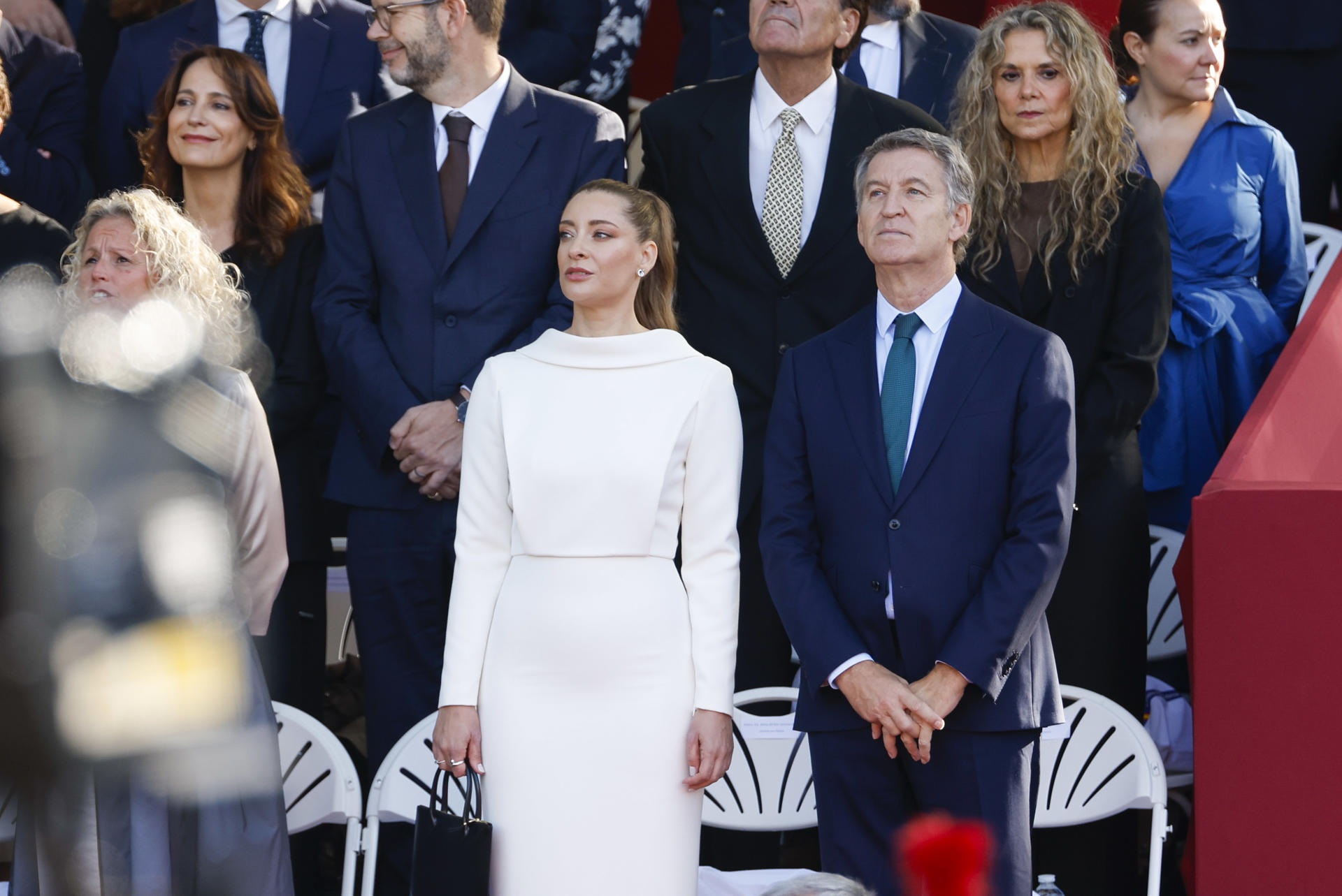 MADRID, 12/10/2026.- El líder del Partido Popular (PP), Alberto Núñez Feijóo (d), y la portavoz del PP, Ester Muñoz (c), asisten al día de la Fiesta Nacional en el que casi 4.400 militares marcharán por las calles de Madrid, una celebración con la que cada 12 de octubre se rinde homenaje a los 120.000 hombres y mujeres que integran las Fuerzas Armadas. EFE/ Daniel Gonzalez