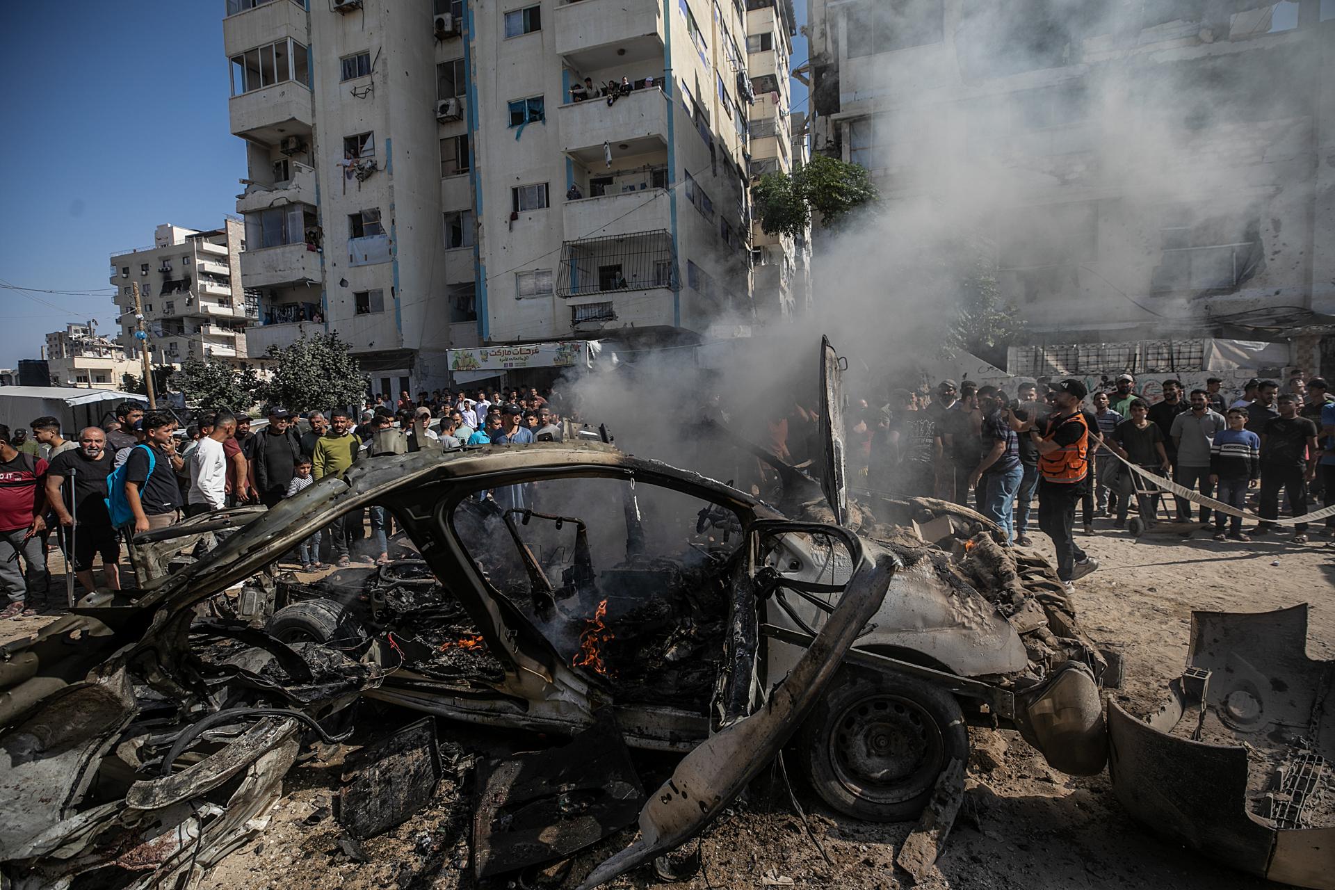 GAZA CITY (---), 22/10/2026.- Palestinian firefighters attempt to extinguish a fire in a vehicle destroyed in an Israeli airstrike south of Gaza City, 22 October 2026. According to the Ministry of Health in Gaza City, at least two Palestinians were killed in the strike. EFE/EPA/MOHAMMED SABER