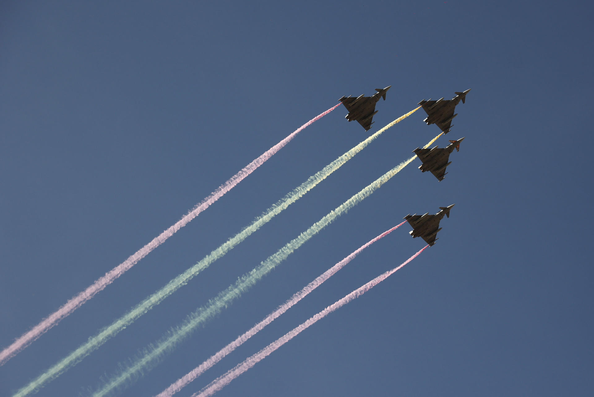 MADRID, 12/10/2026.- La patrulla Águila realiza maniobras durante el tradicional desfile militar por las calles del centro de Madrid en el que participan casi 4.400 militares, 144 vehículos, 39 motos, 50 aviones y 32 helicópteros, este lunes Día de la Fiesta Nacional. EFE/ Daniel Gonzalez