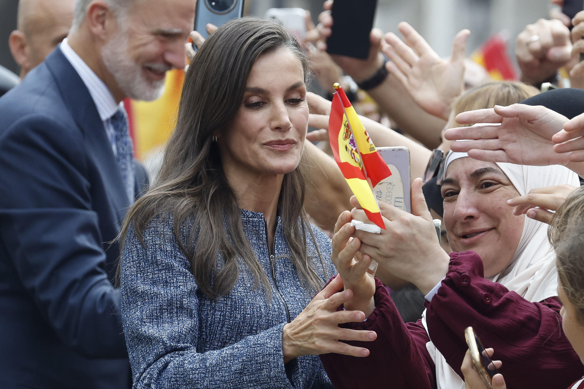CEUTA, 13/10/2026.- La reina Letizia (i) saluda a la multitud que espera su llegada ante el Ayuntamiento de CEuta, este martes. Los reyes han aterrizado este martes en el helipuerto de Ceuta donde a las 12:30 comenzarán su agenda de actos de esta visita histórica, la primera que realizan a la ciudad, para expresar su apoyo a los ceutíes tras la entrada masiva de migrantes a finales del pasado mes de julio. EFE/Chema Moya