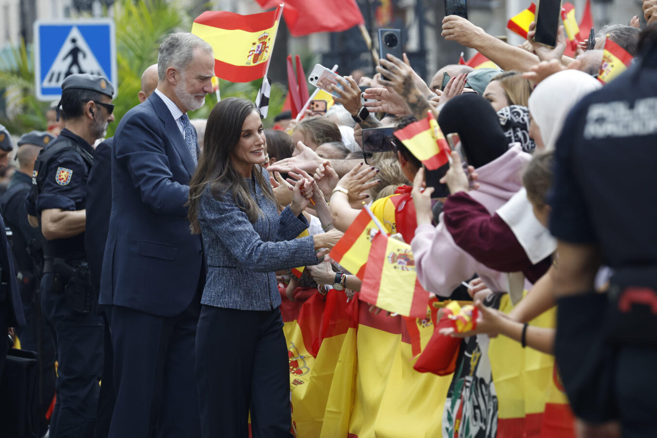 FOTODELDÍA CEUTA, 13/10/2026.- El rey Felipe VI (i, atrás) y la reina Letizia (c) saludan a la multitud que espera su llegada ante el Ayuntamiento de CEuta, este martes. Los reyes han aterrizado este martes en el helipuerto de Ceuta donde a las 12:30 comenzarán su agenda de actos de esta visita histórica, la primera que realizan a la ciudad, para expresar su apoyo a los ceutíes tras la entrada masiva de migrantes a finales del pasado mes de julio. EFE/Chema Moya