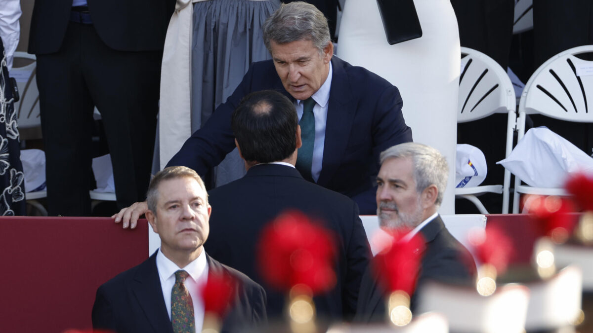 MADRID, 12/10/2026.- El presidente de las Islas Canarias, Fernando Clavijo (d); el presidente de Castilla la Mancha, Emiliano García-Page (i), y el líder del Partido Popular, Alberto Nuñez-Feijóo (c, arriba), durante el tradicional desfile militar por las calles del centro de Madrid en el que participan casi 4.400 militares, 144 vehículos, 39 motos, 50 aviones y 32 helicópteros, este lunes Día de la Fiesta Nacional.- EFE/ Ballesteros