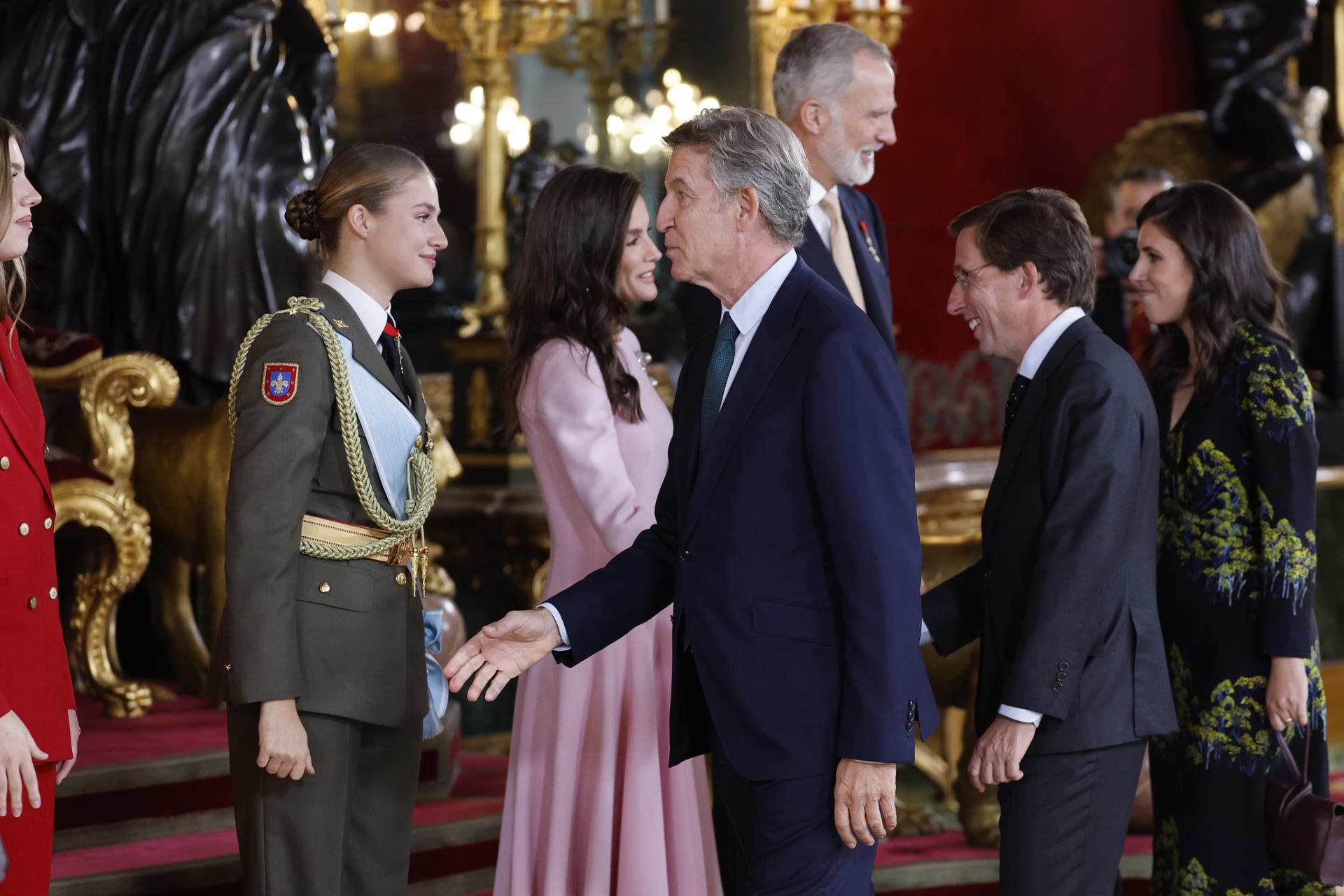 MADRID, 12/10/2026.- La infanta Sofía, la princesa Leonor, la reina Letizia y el rey Felipe VI saludan al líder del Partido Popular, Alberto Núñez-Feijóo (c), y al alcalde de Madrid, José Luis Martínez-Almeida (2d), y a la esposa del alcalde, Teresa Urquijo y Moreno (d), durante el besamanos celebrado en el Palacio Real durante la recepción de la Fiesta Nacional, este lunes, en Madrid. EFE/Mariscal
