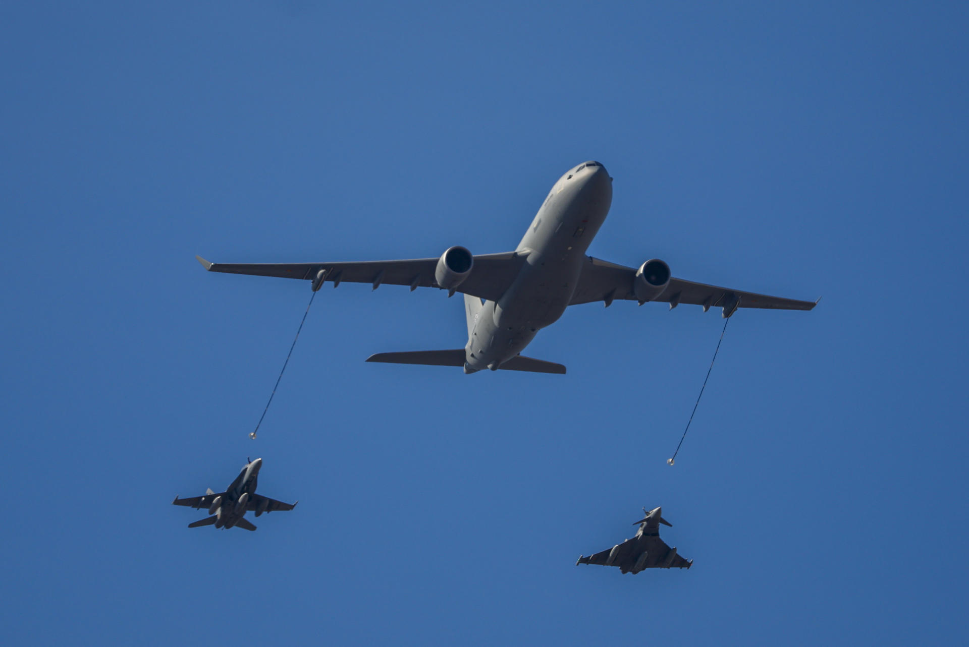 MADRID, 12/10/2026.- Un avión A330 MRTT de reabastecimiento en vuelo, un caza EF-18 Hornet (i), y un caza Eurofighter Typhoon (d) del Ejército del Aire y del Espacio de España, durante el tradicional desfile militar por las calles del centro de Madrid en el que participan casi 4.400 militares, 144 vehículos, 39 motos, 50 aviones y 32 helicópteros, este lunes Día de la Fiesta Nacional. EFE/ Daniel González