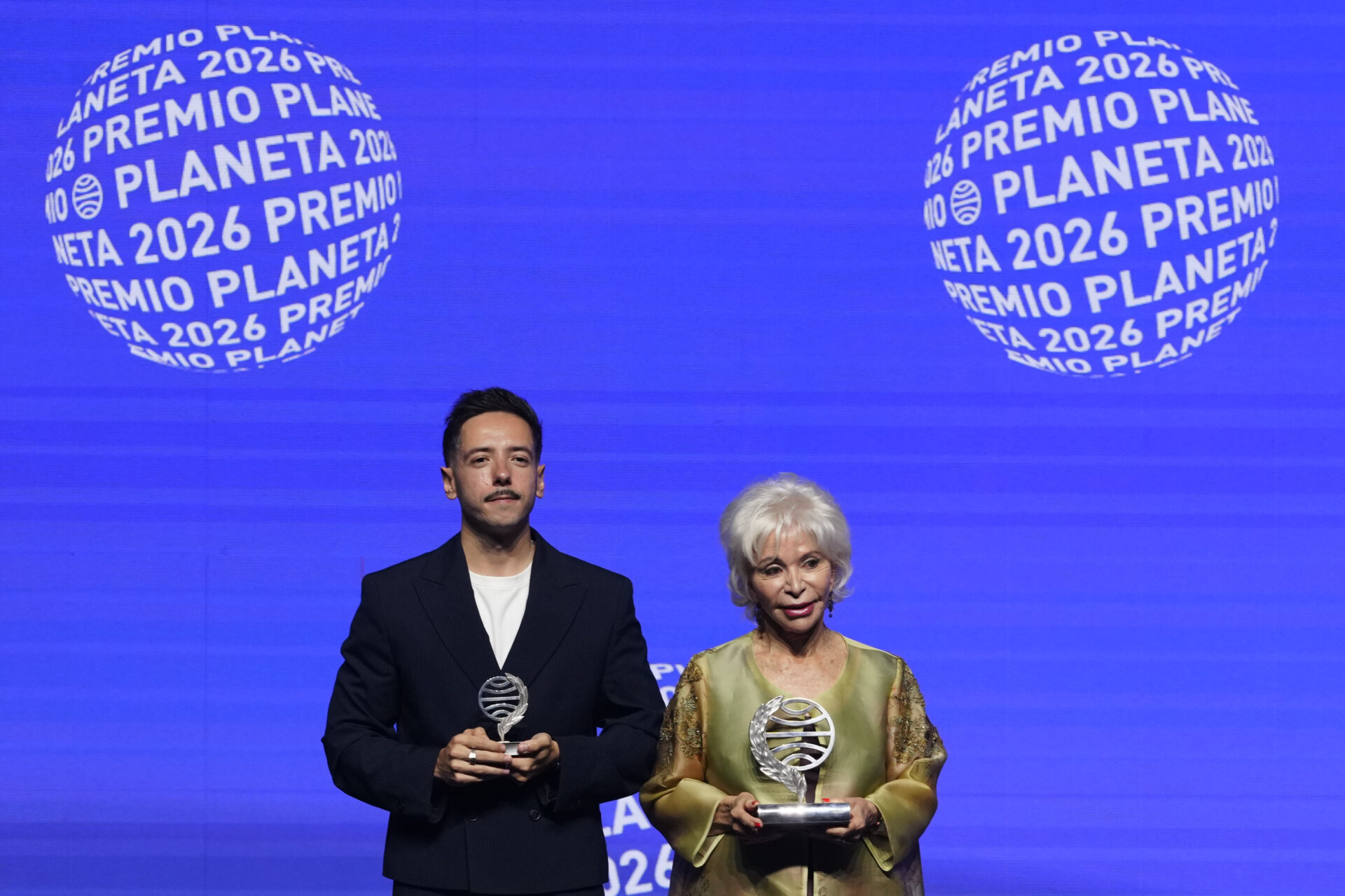BARCELONA, 15/10/2026.- La escritora chilena Isabel Allende (d), ganadora del Premio Planeta 2026 con 'La hora antes del Alba', y el escritor Sergio Hernández Carrasco (i), finalista con su novela 'La añoranza', posan en la 75 edición del Premio Planeta de novela, esta noche de jueves en Barcelona. EFE/ Alejandro García